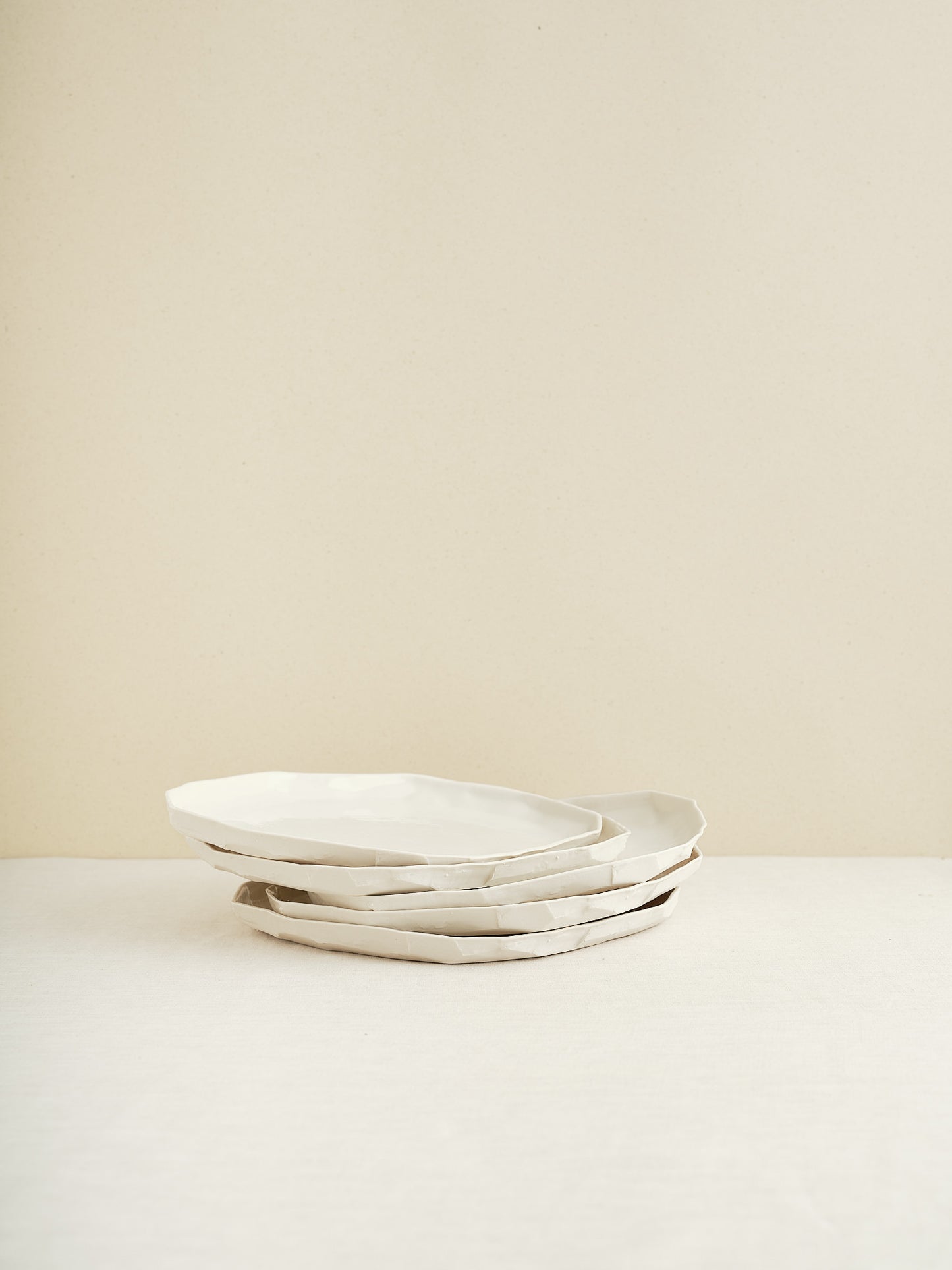 This flat porcelain plate is handmade in Zurich and features a unique, minimalist form that beautifully frames whatever is served on it.