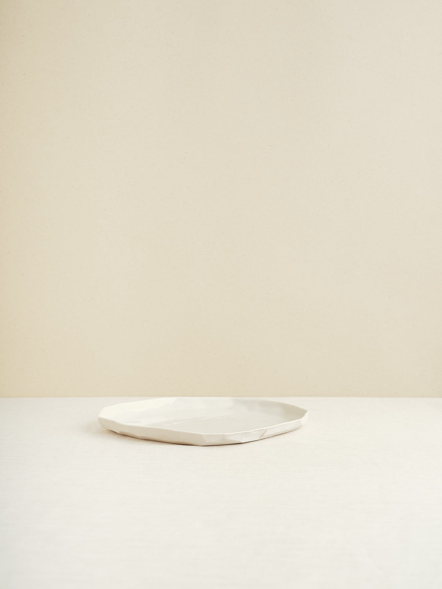 This flat porcelain plate is handmade in Zurich and features a unique, minimalist form that beautifully frames whatever is served on it.