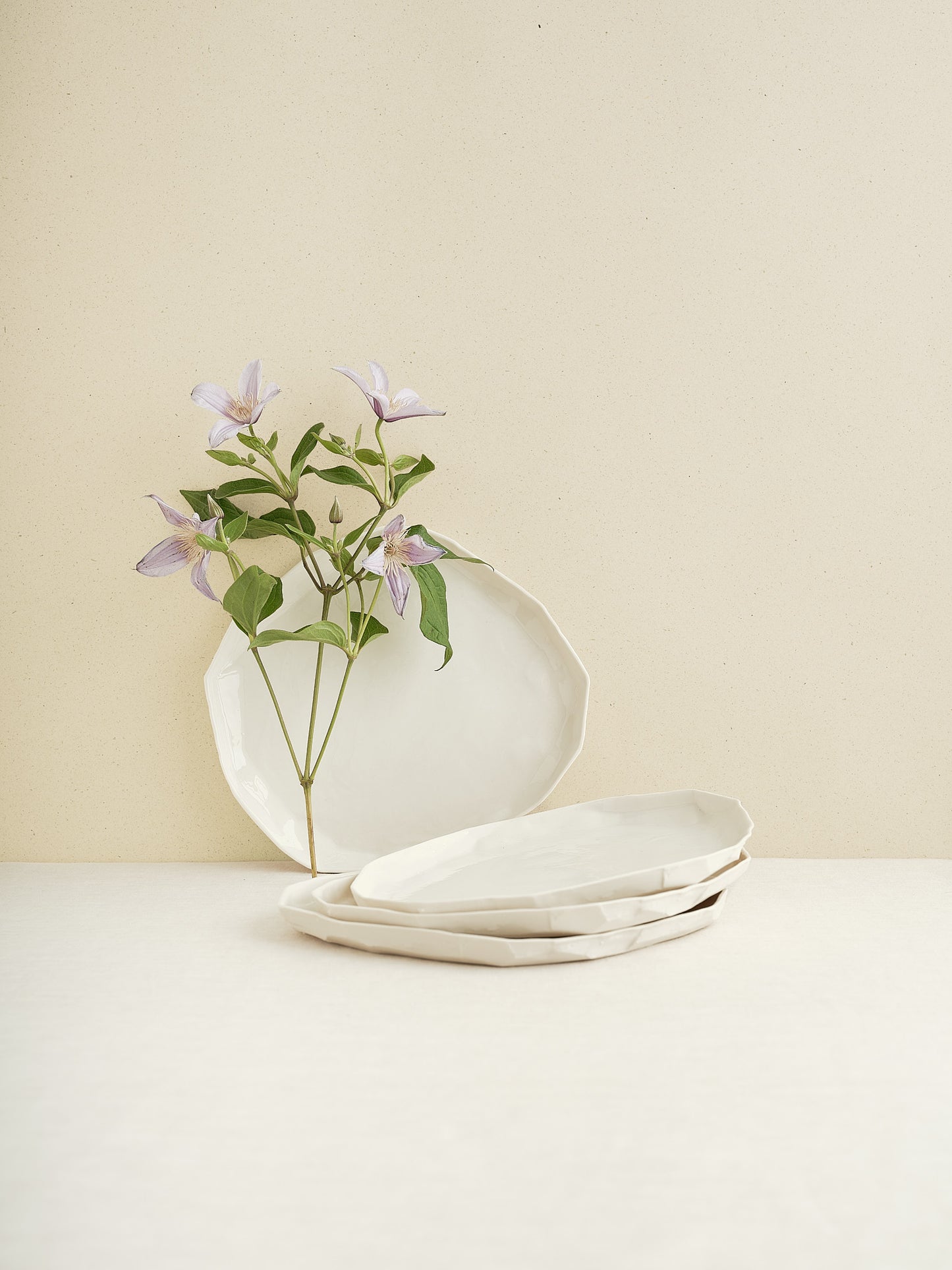 This flat porcelain plate is handmade in Zurich and features a unique, minimalist form that beautifully frames whatever is served on it.